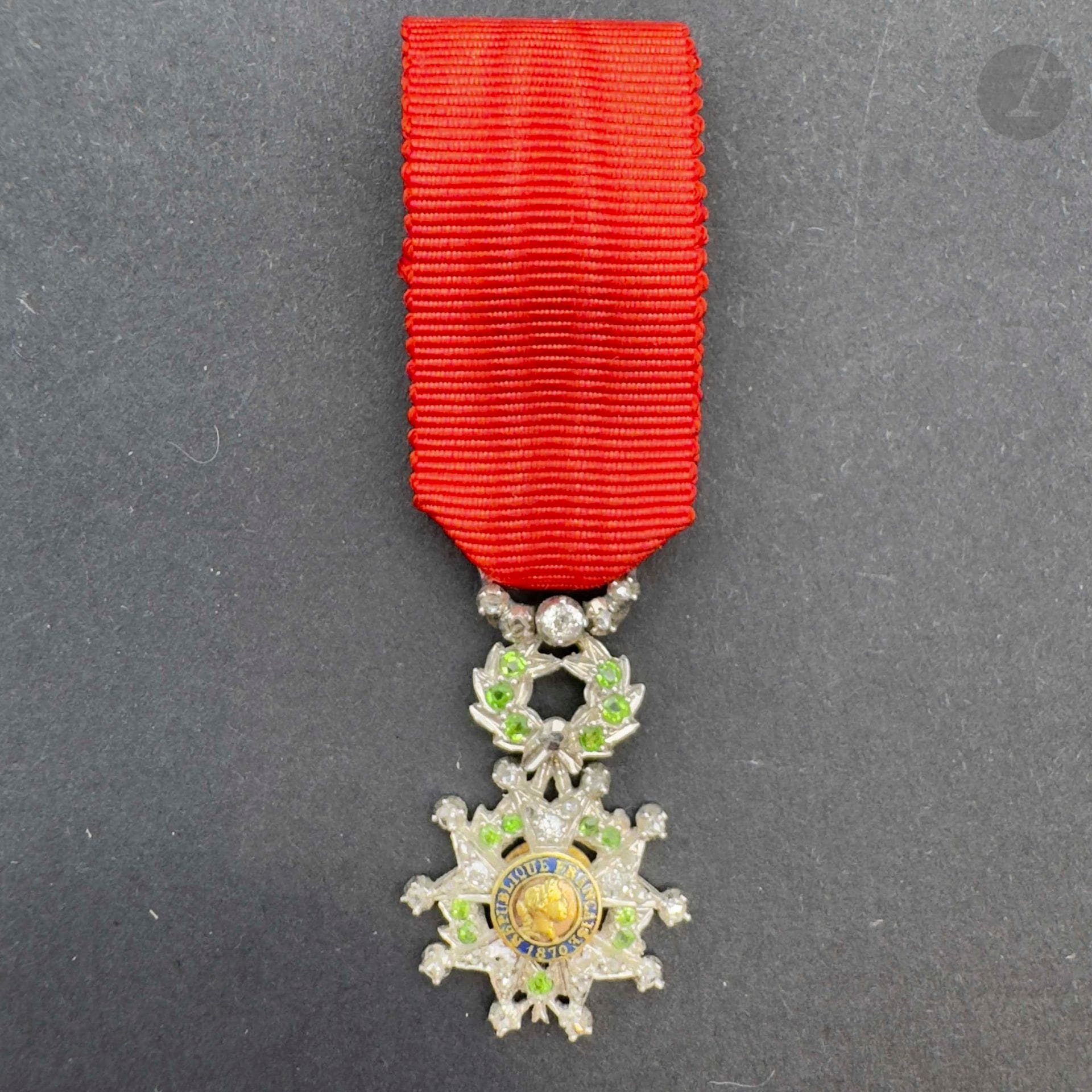 FRANCE
ORDRE DE LA LÉGION D’HONNEUR 
Étoile de chevalier, miniature, d’époque IIIe République. 
En platine, entièrement sertie sur les branches et la couronne de petits diamants et émeraudes. Centres en or en deux parties. 
26 x 17 mm - Poids brut: 3,2 g 
Dans son écrin en maroquin bordeaux (usure) avec plaque d’attribution gravée « le personnel de la succursale de la banque de france a son directeur le baron j de cointet bordeaux le 12 juillet 1924» 
T.T.B.
