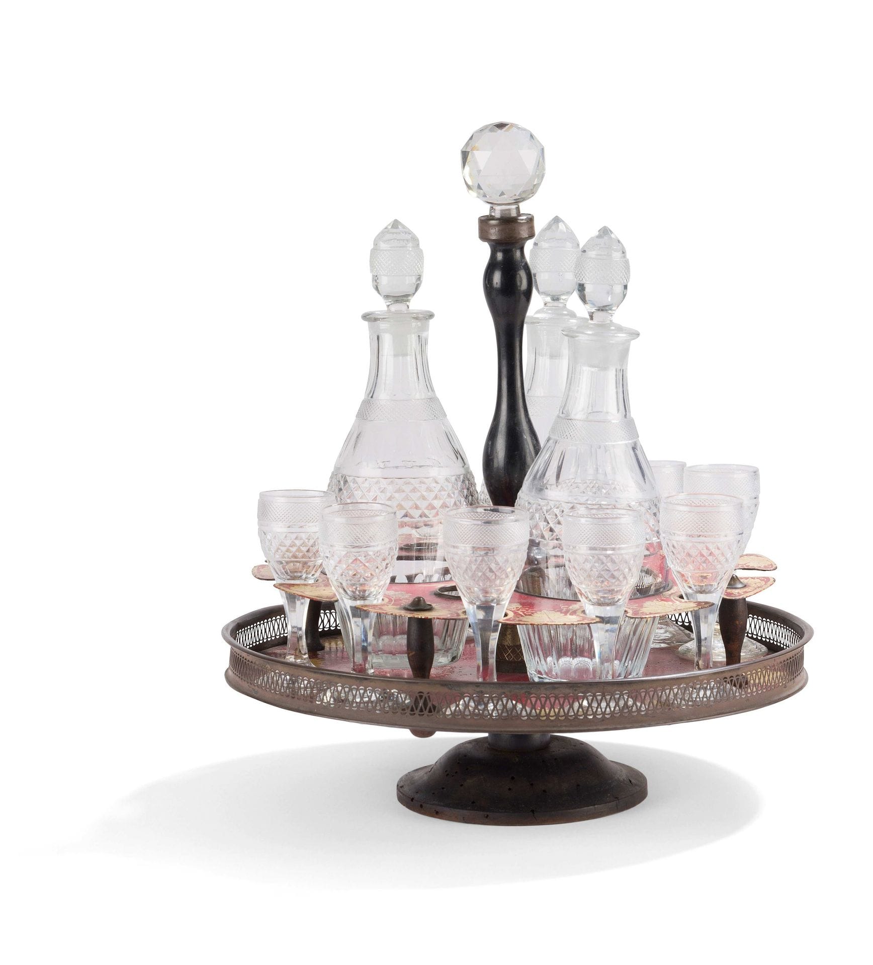 Cabaret in painted sheet metal and turned wood, decorated in gold on a red background with foliage, containing nine glasses and three carafes and cut glass (missing and worn).
Early 19th century.
H. 37 cm, D. 31 cm