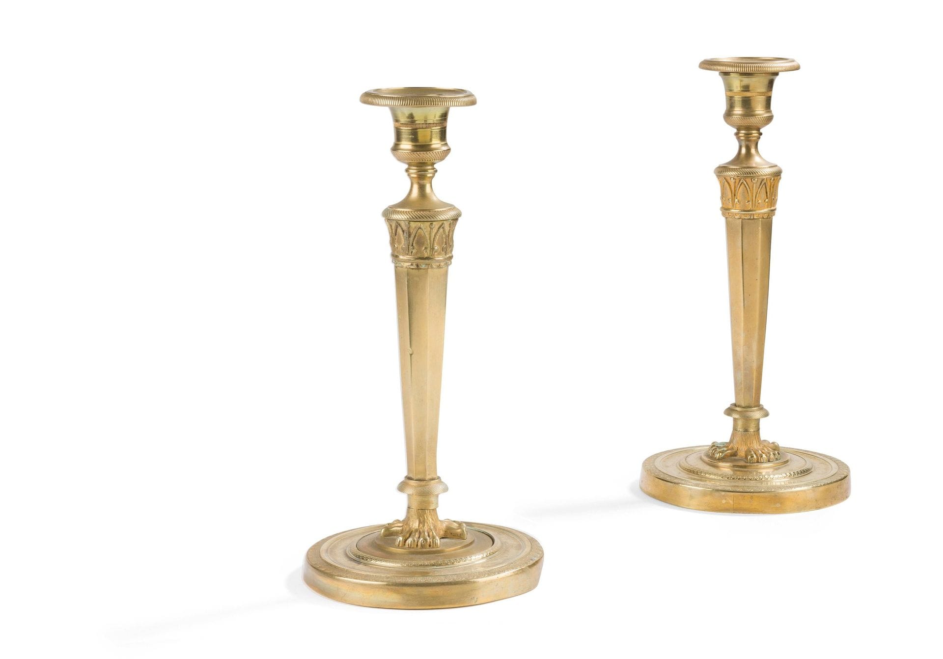 Pair of bronze torches (formerly gilded), the tapered shaft resting on a circular base with guilloché decoration; (accidents and restorations).
Empire period.
H. 26 cm