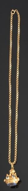 Collier en or jaune, maillons carrés, retenant un pendentif en forme de cachet en or jaune, agrémenté de pierres bleues. Poids: 24,8 g