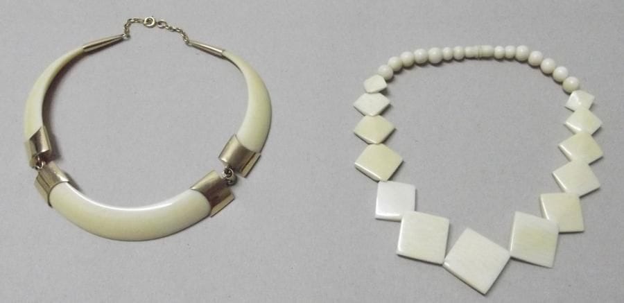 Lot de deux colliers en ivoire, l'un articulé de motifs losangiques, l'autre de motifs courbes et attaches en métal doré.