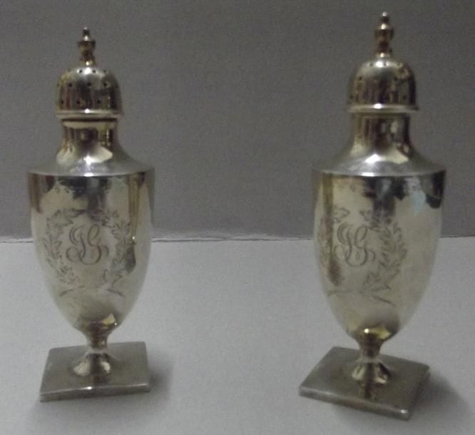Paire de saupoudoirs balustres en argent reposant sur une base carrée, gravés JG. ETATS-UNIS. Orfèvre: Théodore STARR (1900 - 1924). Poids: 120 g