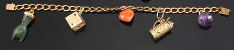Bracelet en or jaune, maillons gourmette, retenant cinq charms en pampille: une perle d'améthyste, une chope en or jaune ciselé, un coeur en corail, un dé à jouer en or jaune guilloché (14K), une main en néphrite. Poids brut: 31,7 g