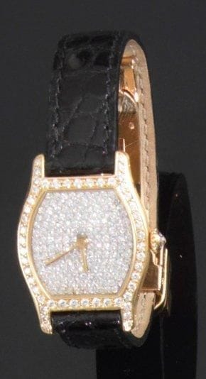 CARTIER
Montre de dame en or jaune, modèle «Tortue», la lunette et le fond sertis et pavés de diamants, couronne sertie d'un diamant, bracelet en crocodile à boucle déployante en or jaune, mouvement mécanique. Signée et numérotée. Poids brut: 29,9 g