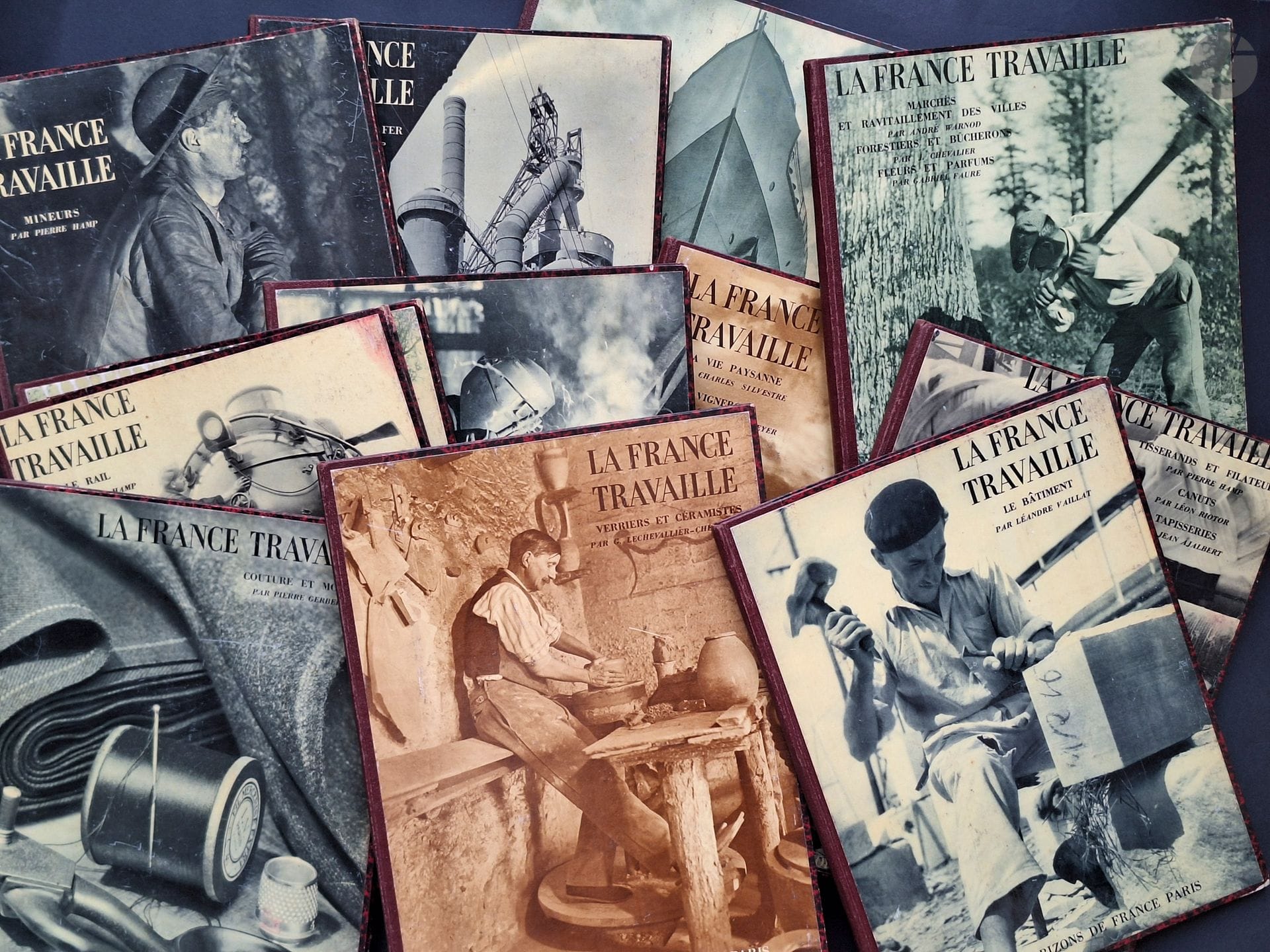 KOLLAR, FRANÇOIS (1904–1979)
15 volumes.
France at Work.
Éditions Horizons de France, Paris, 1932–1934.
In-4 (32.5 x 24.5 cm). First editions. Photographs by François Kollar, superbly printed in heliogravure. Texts by Pierre Hamp, Jean Prévost, Émile Condroyer, Charles Le Goffic, Hervé Lauwick, Lucien Fabre, Charles Silvestre, M. Constantin-Weyer, André Warnod, J. Chevalier, Gabriel Faure, Léon Riotor, Jean Ajalbert, Pierre Gerber, G. Chevallier-Chevignard, Léandre Vaillat, Henri Pourrat, Georges Lecomte, André Thérive, Henry Joly, and Jean Rostand.
Complete 15-volume series: 1: Miners; 2: Ironworking trades; 3: Riverboatmen and boatmen, seafarers; 4: Life at the lighthouses; 5: Railroads; 6: Automobiles, airplanes; 7: Sources of energy; 8: rural life, winegrowers; 9: markets and urban supply, foresters and lumberjacks, flowers and perfumes; 10: weavers and spinners, silk weavers, tapestries; 11: dressmaking and fashion; 12: Glassmakers and Ceramists; 13: Construction; 14: Paper Mills, Book trades; 15: Newspapers, Libraries, Laboratories.
Publisher’s binding with a photographic illustration on the cover. Corners slightly rounded; front cover shows signs of rubbing, sometimes significant; minor foxing on the endpapers of some copies. A 15-volume series, rarely complete.