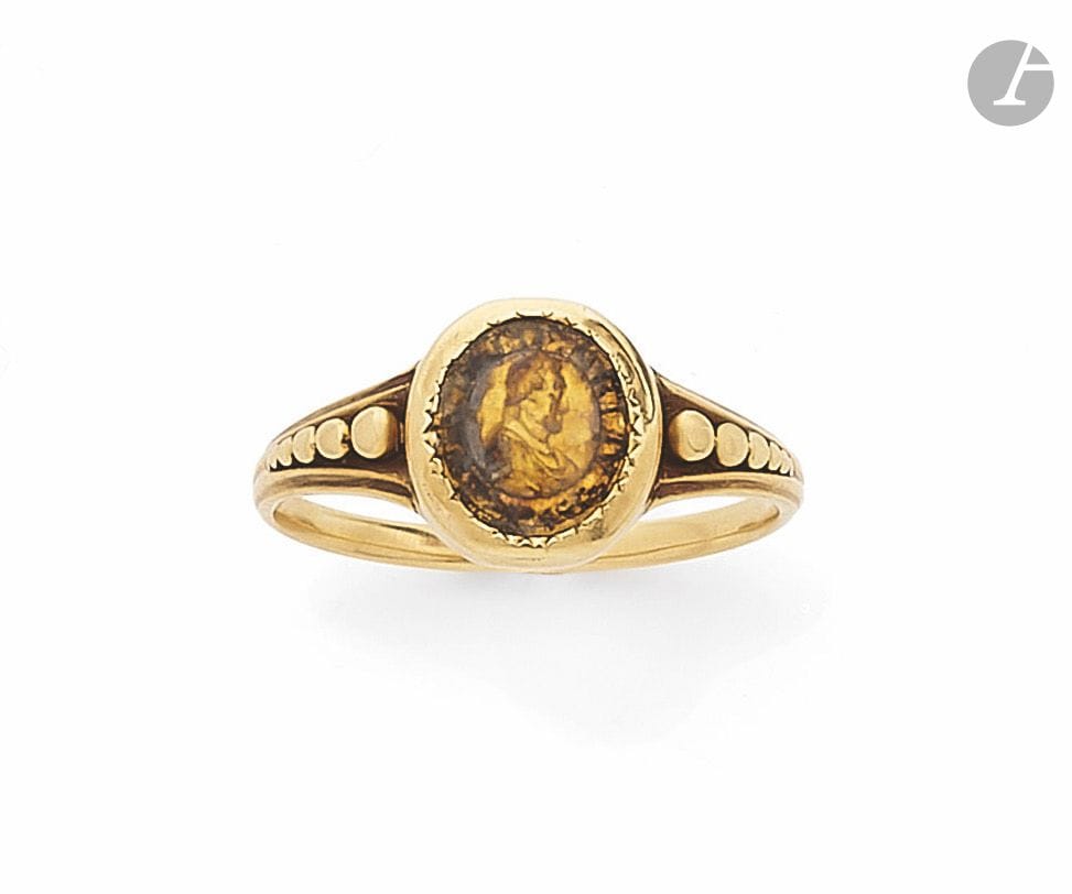 Bague en or 18K (750), ornée du portrait du roi Henri IV de profil couronné d'une inscription le mentionnant. Travail du début du XIXe siècle. Tour de doigt : 57. Poids brut : 2,6 g (altérations)