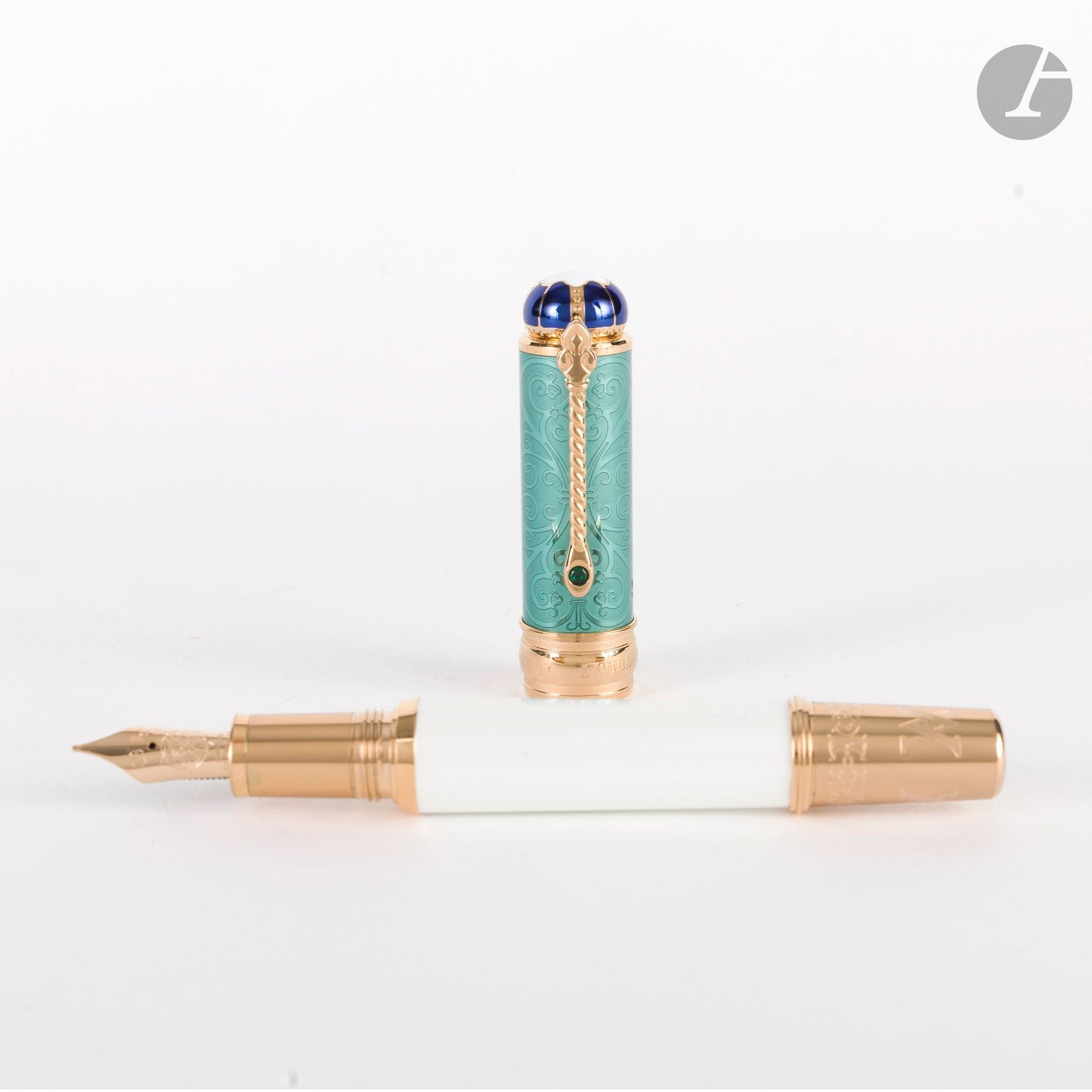 MONTBLANC 
Collection Patron of art Homage to Victoria and Albert, "Homage to Victoria"
Stylo plume laque blanche et verte, résine.  Corps du stylo en or 18K (750). Numéroté 0429/4810. Système remplissage à piston. 
Plume taille M en or 18K (750) datée de 2022. 
Capuchon dévissable et agrafe sertie d'une pierre verte synthétique.
Avec deux plastiques protecteurs, son coffret d'origine et son étui en carton, son livret auquel est attaché un certificat de garantie daté du 17 décembre 2023. 

Ce stylo, dernier édité de la collection "Patron of Art" est édité conjointement au stylo "Homage to Albert". Le capuchon du stylo est orné de la citation "I will be good", phrase que Victoria aurait prononcé au moment de son accession au trône en 1837, alors qu'elle n'a que 18 ans.
Le blanc perle rappelle sa jeunesse et sa pureté, tandis que le vert clair était une de ses couleurs préférées. Sous la laque, des motifs inspirés de l'esthétique victorienne sont visibles, rappelant les abords de l'Albert Memorial aux Kensington Gardens. Le haut du capuchon reprend le motif de la couronne si souvent portée par la reine Victoria.