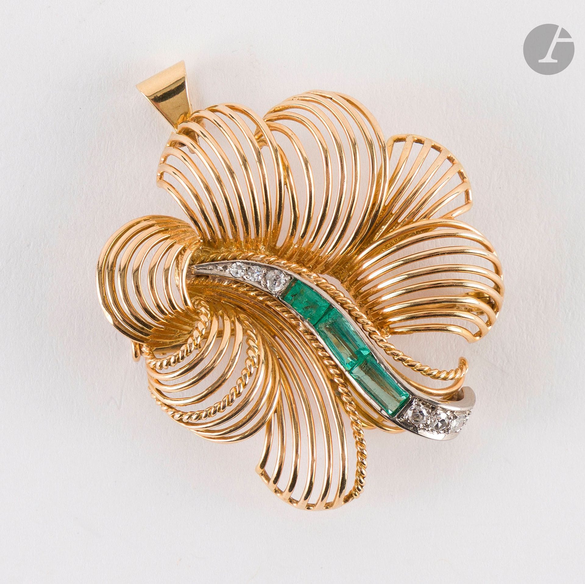 18K gold (750) brooch-pendant featuring gold wires forming a feather; the feather’s vein is set with 8/8 diamonds and 3 calibrated emeralds. French craftsmanship from the 1960s. Height: approximately 3.8 cm. Gross weight: 13.4 g (scratches, missing material)