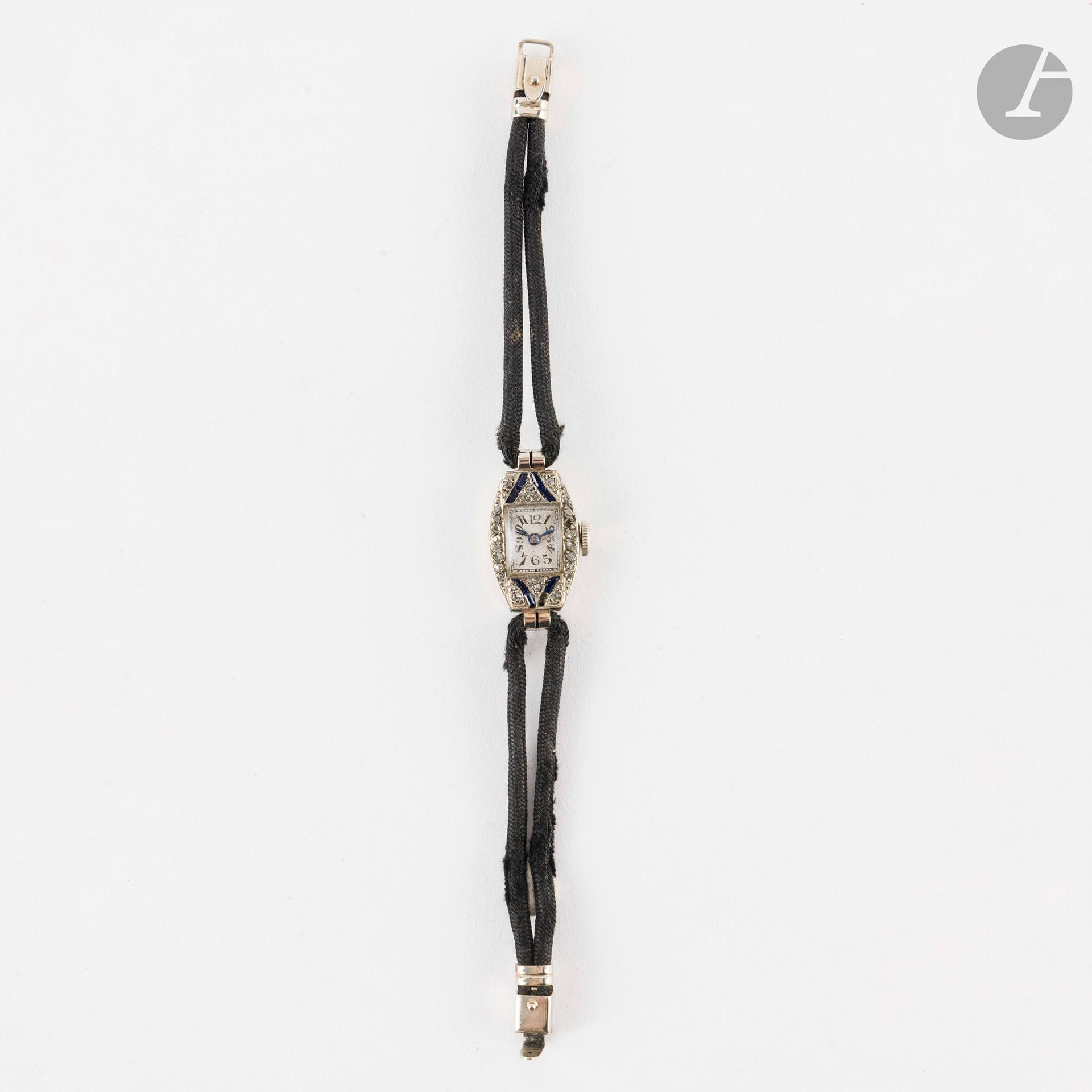 Montre de dame en or gris 18K (750), sertie de saphirs calibrés synthétiques et de diamants taillés en roses. Longueur : 14,5 cm environ. Poids brut : 9,8 g (manques, usures, fonctionnement non garanti)