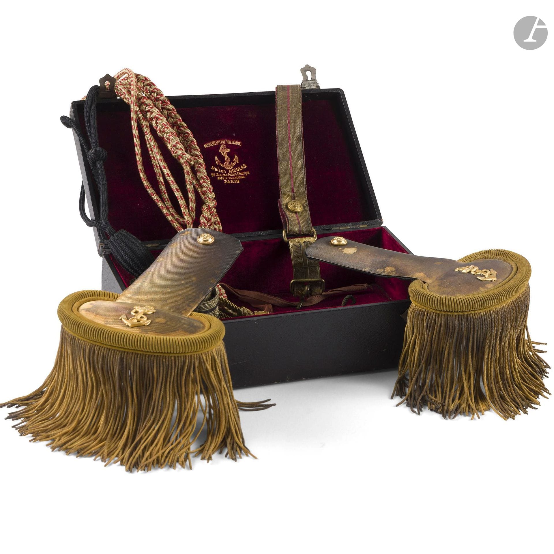 Paire d’épaulettes d’officier de marine. 
En passementerie dorée à petites franges à motifs à l’ancre et boutons dorés. Doublure en velours noir. 
Dans leur boite de la Maison Nicolas, recouverte de toile façon maroquin, à deux attaches, doublée de velours rouge, marquée à l’or dans le couvercle et monogrammée. 
On joint un lot de suspentes, galons et aiguillettes.
IIIe République.