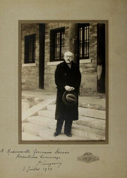 Paul LANGEVIN (1872-1946) physicien. Photographie avec dédicace autographe signée, 3 juillet 1934 ; noir et blanc, à vue 19,5 x 14 cm, sous chemise-cadre cartonnée The Photo Specialists Co.
Beau portrait en pied du savant debout sur des marches, en manteau, avec son chapeau à la main. Sur la marge, il a dédicacé ce cliché à la militante et journaliste Germaine Decaris (1899-1955) : « A Mademoiselle Germaine Decaris Respectueux hommage P. Langevin 3 juillet 1934 ».