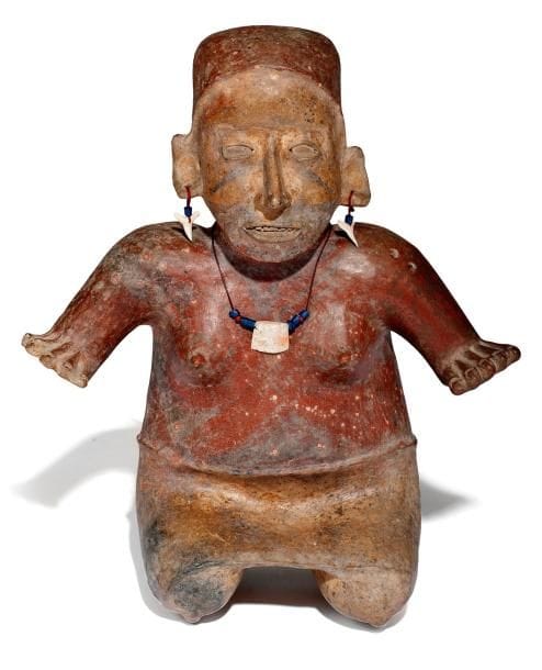 Sculpture représentant une femme. Assise sur ses pieds, elle porte une jupe couleur crème. Le buste resté nu est peint en rouge et décoré de motifs géométriques noirs. Ces peintures corporelles étaient un signe distinctif entre les familles nobles. Les bras sont écartés. Sa bouche ouverte laisse apparaître les dents. Son visage est agrémenté de motifs peints en noir. Les oreilles sont percées et une coiffe rouge enserre sa tête. Les bijoux qu?elle porte sont de facture moderne. Terre cuite brune à engobe rouge, crème et décor noir. Trous de cuisson sur le côté de la coiffe. Culture Jalisco, Mexique 100 av. - 250 ap. J.-C. H: 37 cm - l: 31 cm - Ep: 15 cm État: bon. Quelques éclats dans l?engobe. Provenance: collection privée, Paris