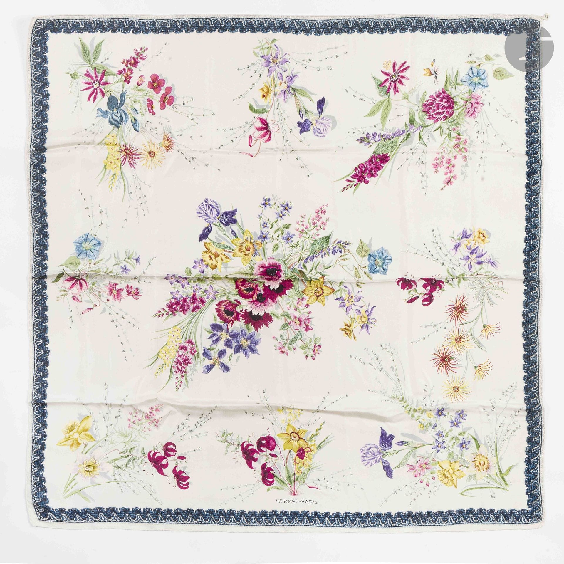 HERMÈS PARIS
"Fleurs et Galons" 90 Carré in silk twill, with a white background and a border of braiding in shades of blue. Based on a design by Gabriella La Torre
(some marks)

See variations in lot 39

Provenance:
Collection of the artist’s family. Assembled under the direction of Fabrizio La Torre, son of Gabriella La Torre, this collection reflects a desire to recreate a body of work that brings together the artist’s archives and pieces produced by Hermès.

Gabriella La Torre (Rome, 1894–1976) was a porcelain painter. Over several decades, she developed a distinctive body of work inspired in particular by her love of the decorative arts and antique porcelain, whose designs she studied and collected.

Beginning in 1957, she collaborated with Hermès, for which she created numerous designs that gave rise to silk scarves, ready-to-wear pieces, and porcelain objects. Her creative vision gave rise to patterns such as “Insects,” “Flowers and Braids,” “Oranges and Lemons,” “Cherries,” “Roosters,” and “Old China.”