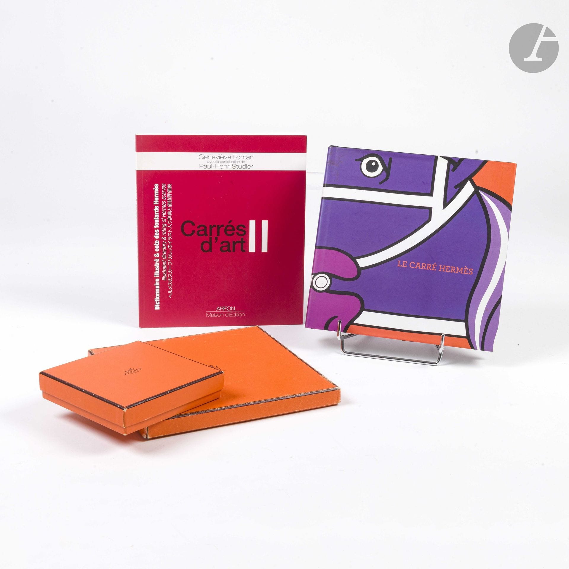 Deux ouvrages sur le thème du carré Hermès :
- Le roman du carré, Nadine Coleno, éditions du regard, 2009
- Carrés d'art II, Geneviève Fontan, éditions Arfon, 2014
(quelques traces d'usage)
On y joint deux boîtes dont une pour carré au couvercle accidenté

Provenance :
Collection de la famille de l'artiste. Réunie sous l'impulsion de Fabrizio La Torre, fils de Gabriella La Torre, cette collection témoigne de la volonté de reconstituer un ensemble mettant en regard les archives de l'artiste et les pièces éditées par la Maison Hermès.

Gabriella La Torre (Rome, 1894–1976) est une artiste peintre sur porcelaine. Elle développe durant plusieurs décennies un travail personnel nourri notamment par son goût pour les arts décoratifs et les porcelaines anciennes, dont elle étudie et collectionne les décors.

À partir de 1957, elle collabore avec la Maison Hermès, pour laquelle elle crée de nombreux motifs qui donneront naissance à des carrés de soie, des pièces de prêt-à-porter et des objets en porcelaine. Son univers est notamment à l’origine de modèles tels que Insectes, Fleurs et Galons, Oranges et Citrons, Cerises, Les Coqs et Vieille Chine.