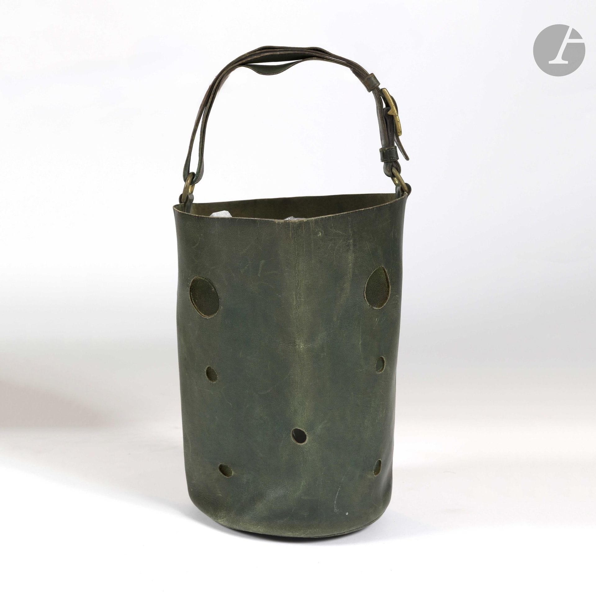 HERMÈS PARIS 24.Fg St HONORÉ
Vers 1950
Sac seau MANGEOIRE en cuir lisse vert ajouré. Garniture en métal doré
H : 28 cm et Diam. : 19,5 cm
(usures et taches, en l'état)