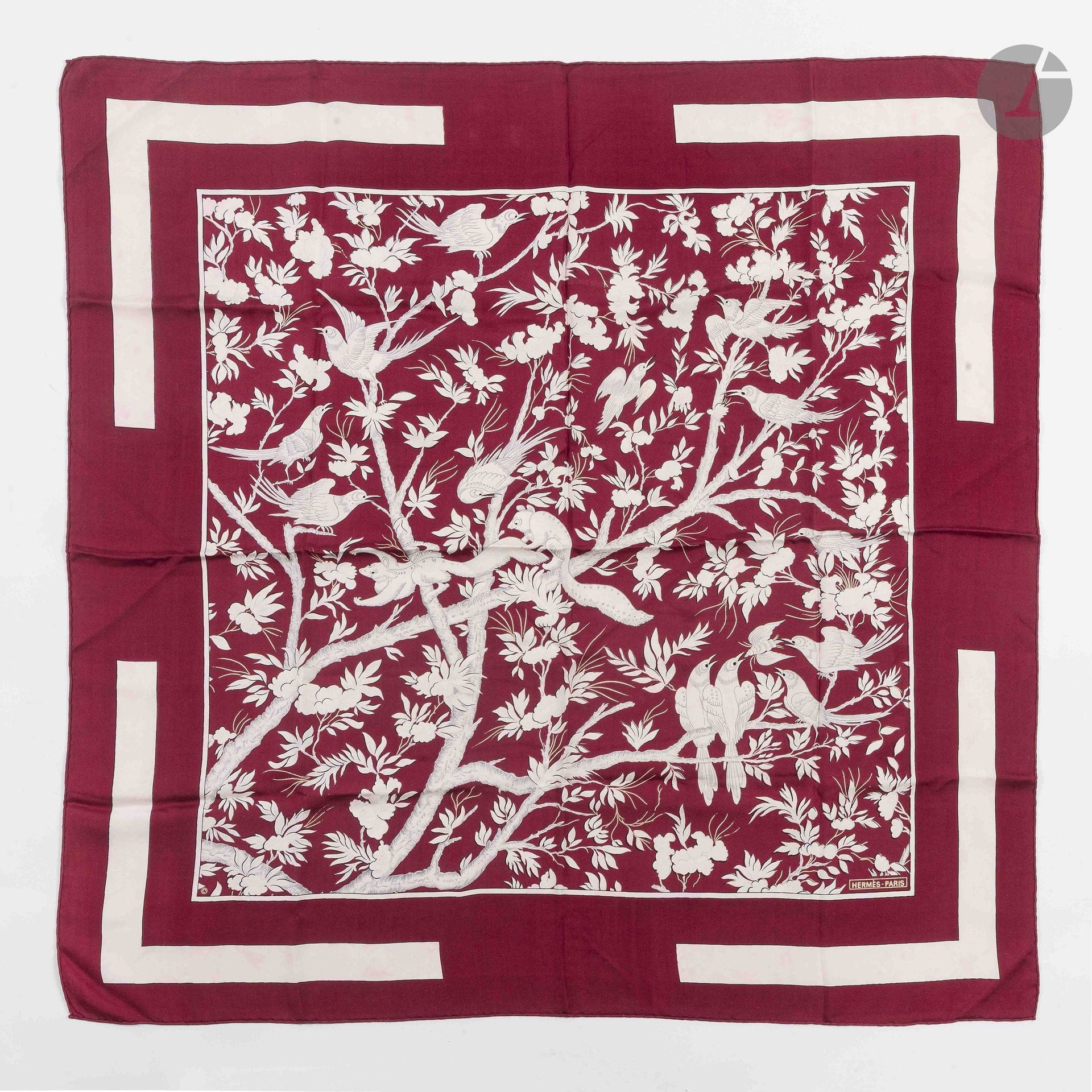 HERMÈS PARIS
Carré 90 en twill de soie Vieille Chine, fond bordeaux avec cadre blanc. D'après un dessin de Gabriella La Torre
(quelques traces de décoloration dans le cadre, quelques traces)

Voir sa pièce source lot 11 et ses déclinaisons lots 12 à 19

Provenance :
Collection de la famille de l'artiste. Réunie sous l'impulsion de Fabrizio La Torre, fils de Gabriella La Torre, cette collection témoigne de la volonté de reconstituer un ensemble mettant en regard les archives de l'artiste et les pièces éditées par la Maison Hermès.

Gabriella La Torre (Rome, 1894–1976) est une artiste peintre sur porcelaine. Elle développe durant plusieurs décennies un travail personnel nourri notamment par son goût pour les arts décoratifs et les porcelaines anciennes, dont elle étudie et collectionne les décors.

À partir de 1957, elle collabore avec la Maison Hermès, pour laquelle elle crée de nombreux motifs qui donneront naissance à des carrés de soie, des pièces de prêt-à-porter et des objets en porcelaine. Son univers est notamment à l’origine de modèles tels que Insectes, Fleurs et Galons, Oranges et Citrons, Cerises, Les Coqs et Vieille Chine.