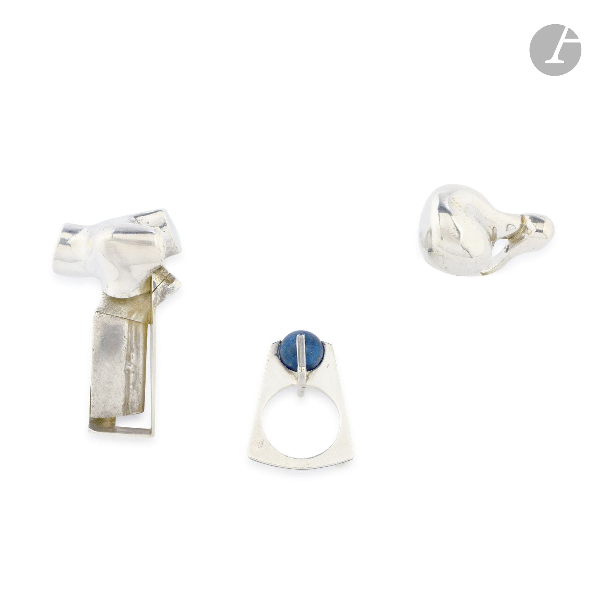 TRAVAIL DES ANNÉES 1970 (NON IDENTIFIÉ) – COLLECTION GALERIE AT HOME TOULOUSE – 3 ŒUVRES
- Bague. Argent 925 ‰. Années 1970. Tour de doigt: 50 – Poids: 27,31g
- Bague moderniste. Argent 800 ‰, lapis lazuli. Signée d’un monogramme non identifié, porte les poinçons de Maître et de garantie. Tour de doigt: 50 - Poids brut: 6,67g
- Bague. Argent 800 ‰. Années 1970. Tour de doigt: 50 – Poids: 21g

Provenance:
Galerie At Home, Toulouse, fondée par Jacques Pulvermacher en 1959.