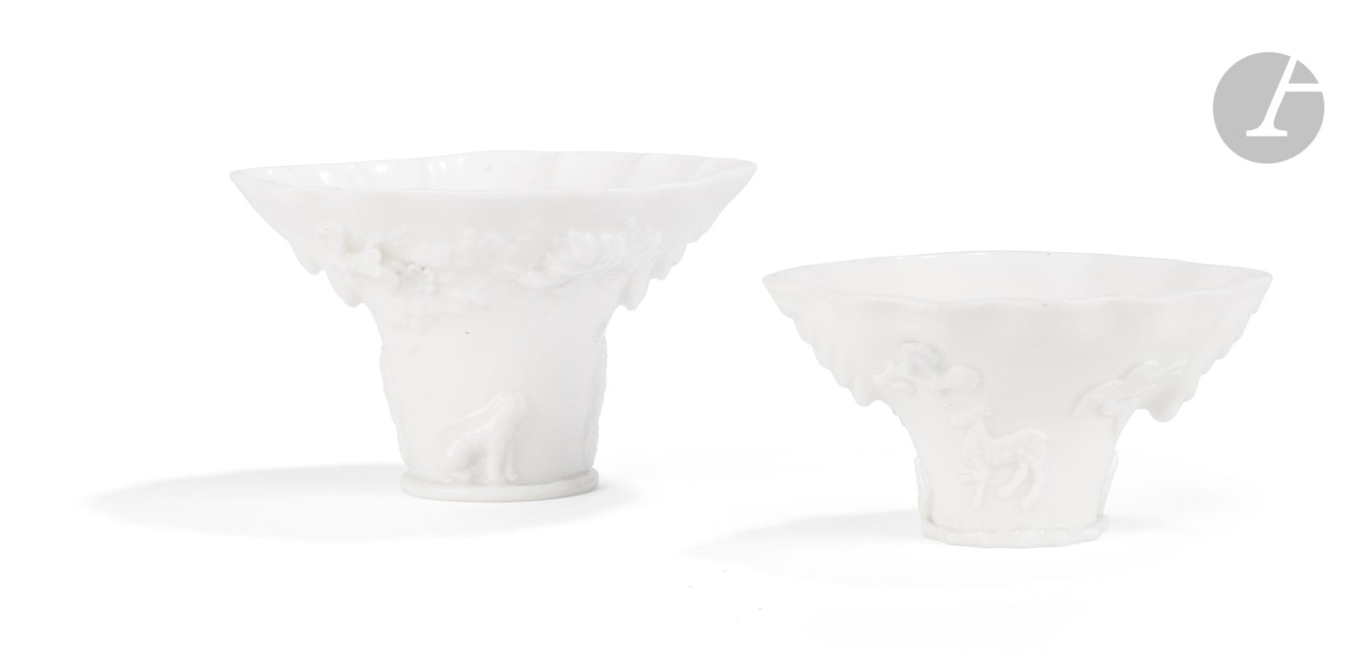 Two libation cups made of white Chinese porcelain, Dehua, China, 18th and 19th centuries
- The first features a relief-molded decoration of two facing dragons, a deer, rocks, and a crane beneath pine trees. The flared rim is lobed, and the base is shaped like a flat, angular rock. Height: 6.9 cm; - The second features a relief-molded decoration of a tiger, a deer, a dragon, rocks, and a crane in flight beneath pine trees. The very flared bowl is lobed and molded with a radiating petal motif on its interior. Height: 9.1 cm
