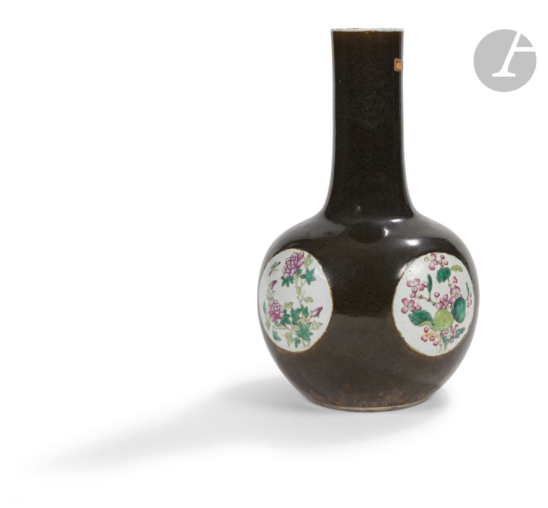 Vase de forme tianqiuping en porcelaine dite « poudre de thé » et décor dans le style de la famille rose, Chine, fin XIXe siècle
À décor de quatre réserves rondes à fond blanc émaillé dans le style de la famille rose de fleurs diverses dont des pivoines avec un papillon et des chrysanthèmes. Le dessous montre une marque apocryphe moulée de Qianlong à six caractères entourée de volutes.
Hauteur : 38 cm