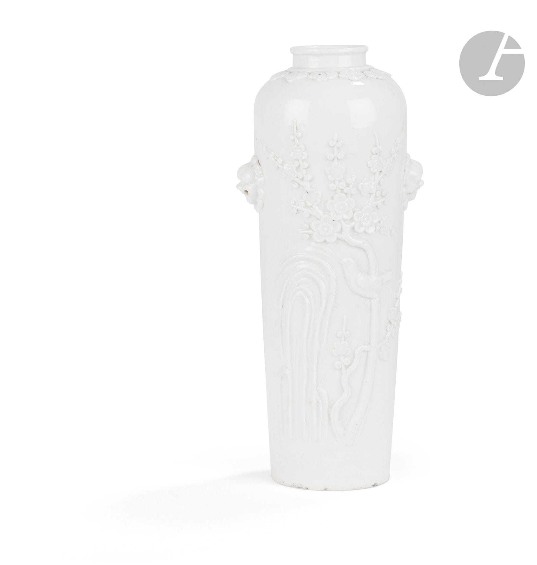 Vase en porcelaine blanc de Chine, Chine, Dehua, XIXe siècle
À décor moulé d’un oiseau perché sur une branche de prunier en fleurs près d’un rocher et incisé de branches de fleurs et végétaux. L’épaulement est orné d’une frise de têtes de ruyi, et la panse agrémentée d’une paire d’anses en forme de masques de lion bouddhiques.
Hauteur : 23 cm