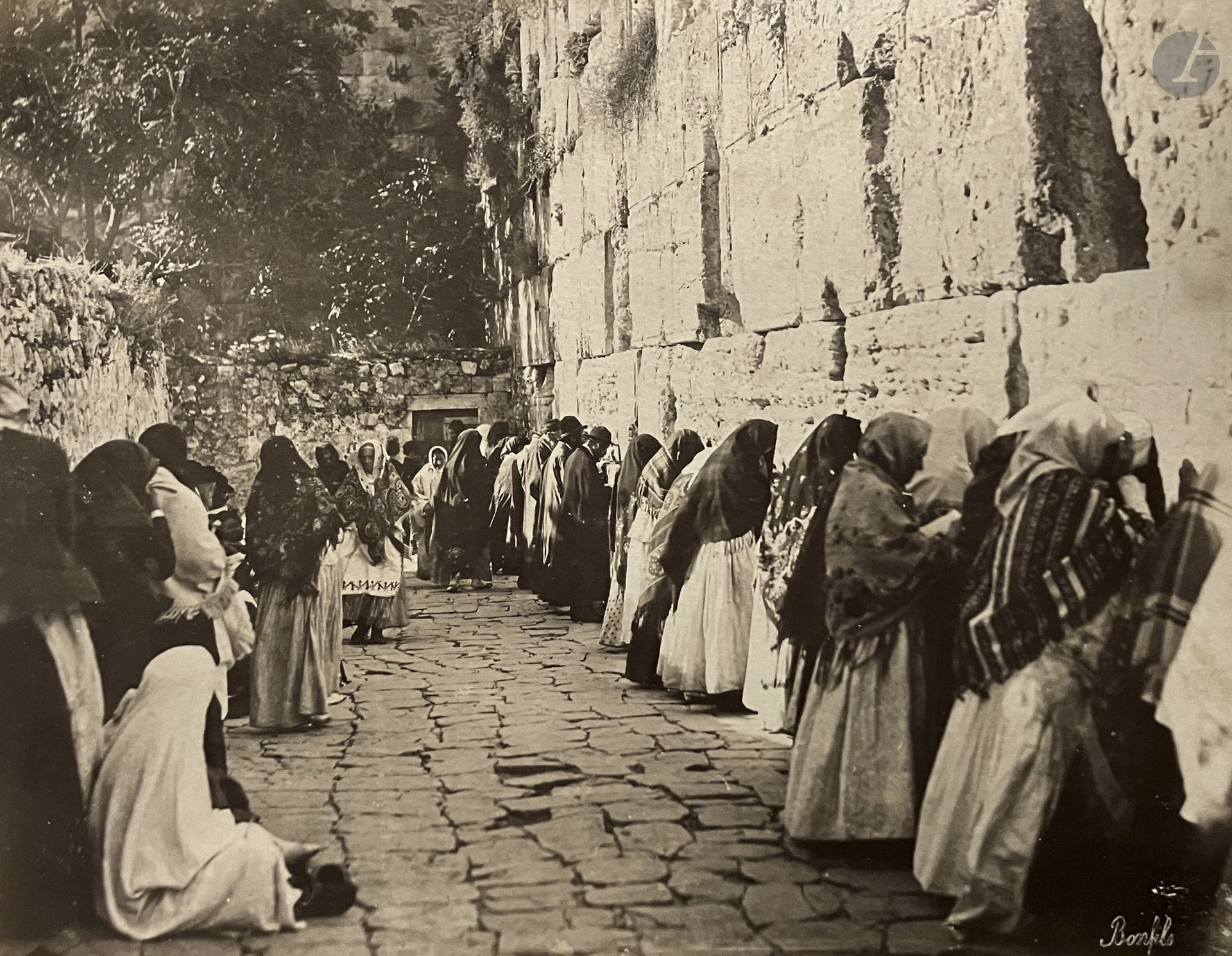 Félix Bonfils (1831–1885)
Photographs of the Holy Land.
F. F. Marroum. Jerusalem, ca. 1870–1880.
Jaffa. Fortress. Panorama of Jerusalem. Western Wall. Church of the Holy Sepulcher. Arch of the Ecce Homo. 12th and 13th Stations. Golden Gate. Mosque of Omar. Damascus Gate. Tomb of David. Fountain of the Virgin. Tombs of the Kings. Pool of Siloam. Valley of Jehoshaphat. Cave of Jeremiah. Tomb of Rachel. Bethlehem. Church of the Nativity. Mar Saba Monastery. Dead Sea. Jericho. Bedouins. Rabbi. 
Oblong in-4 album with wooden covers, titled on the spine and at the beginning of the volume, comprising 50 albumen prints mounted on backing boards. Numerous signatures by the photographer and captions on the negatives.
Average size of the prints: 28 x 22 cm
