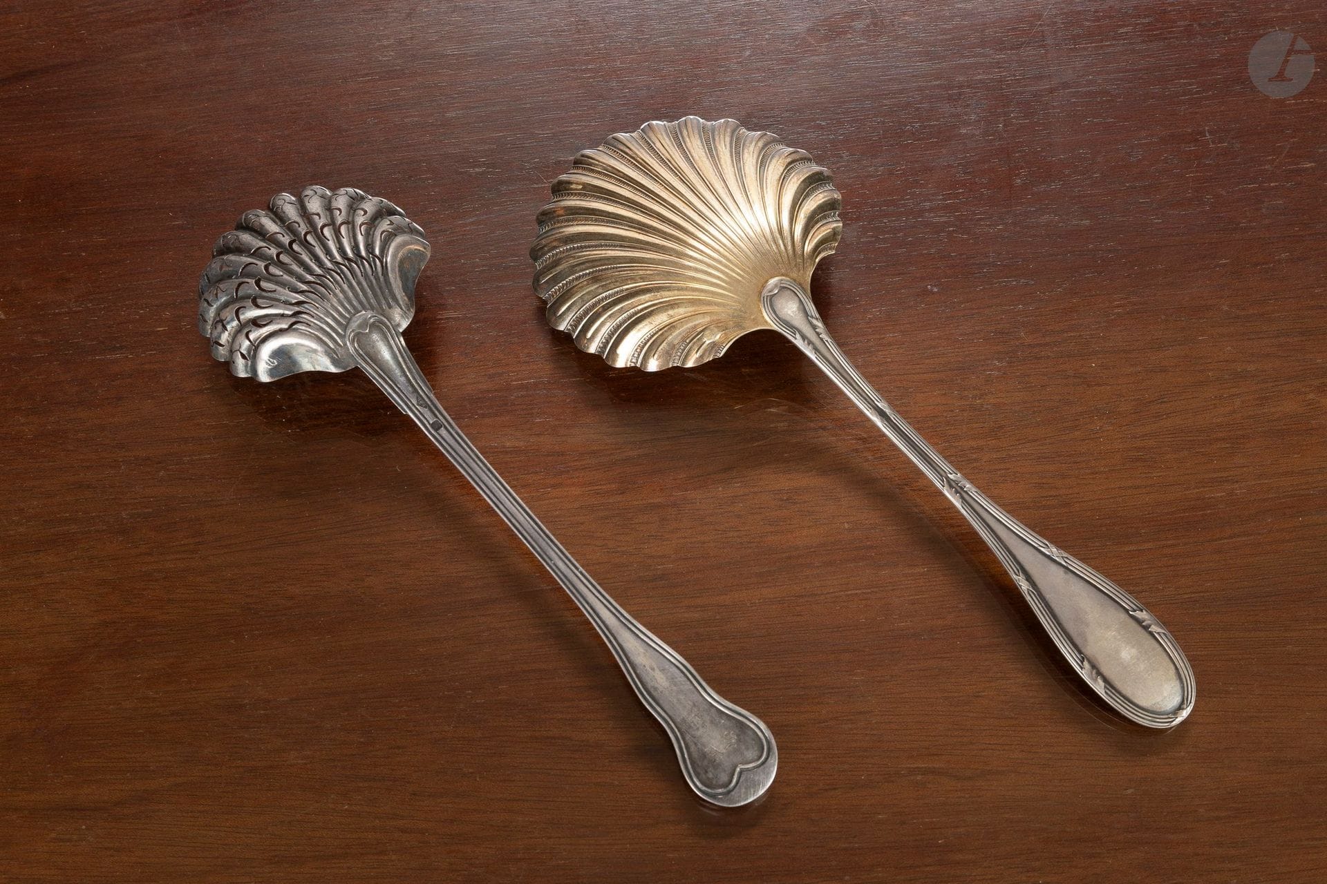 A sugar spoon and a strawberry scoop made of 925°/°° silver; one features a fluted design and a re-drilled bowl, while the other has a vermeil-plated shell-shaped bowl.
France, 19th century. 
Net weight: 149 g

This set comes from the reception hall of the Château d’Arcangues.