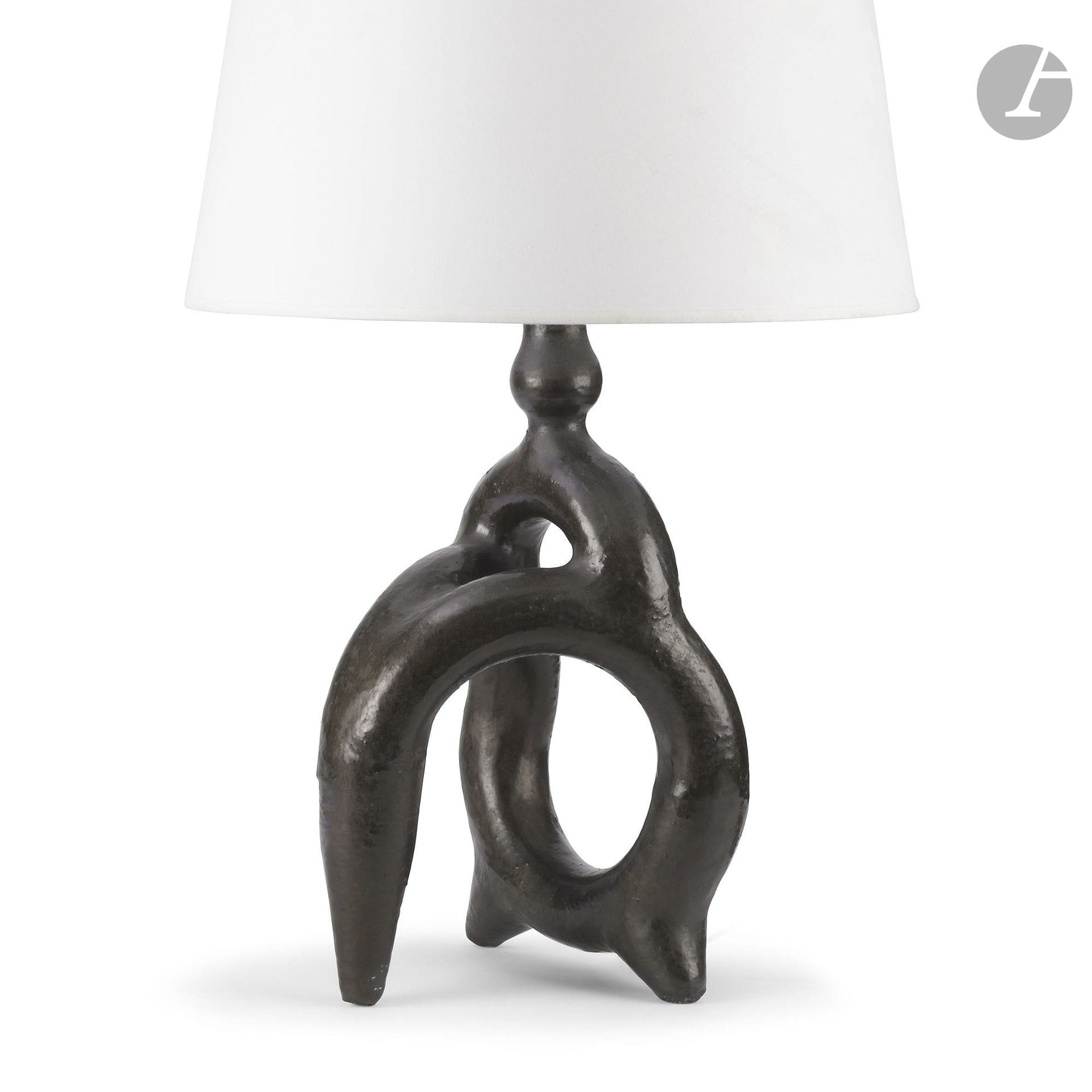 ATELIER MADOURA—founded by Suzanne DOULY-RAMIÉ (1905–1974) and Georges RAMIÉ (1901–1976)
“Le Centaure,” a design created by Suzanne Douly-Ramié
Lamp base.
Glazed ceramic piece; black.
Presented with a double, attached conical lampshade.
Late 1940s, early 1950s.
Base only: H. 39 cm - W. 22 cm
Previous, minor restorations. 

Bibliography:
Mobilier et Décoration - No. 4, May 1951. Identical model reproduced on p. 6.