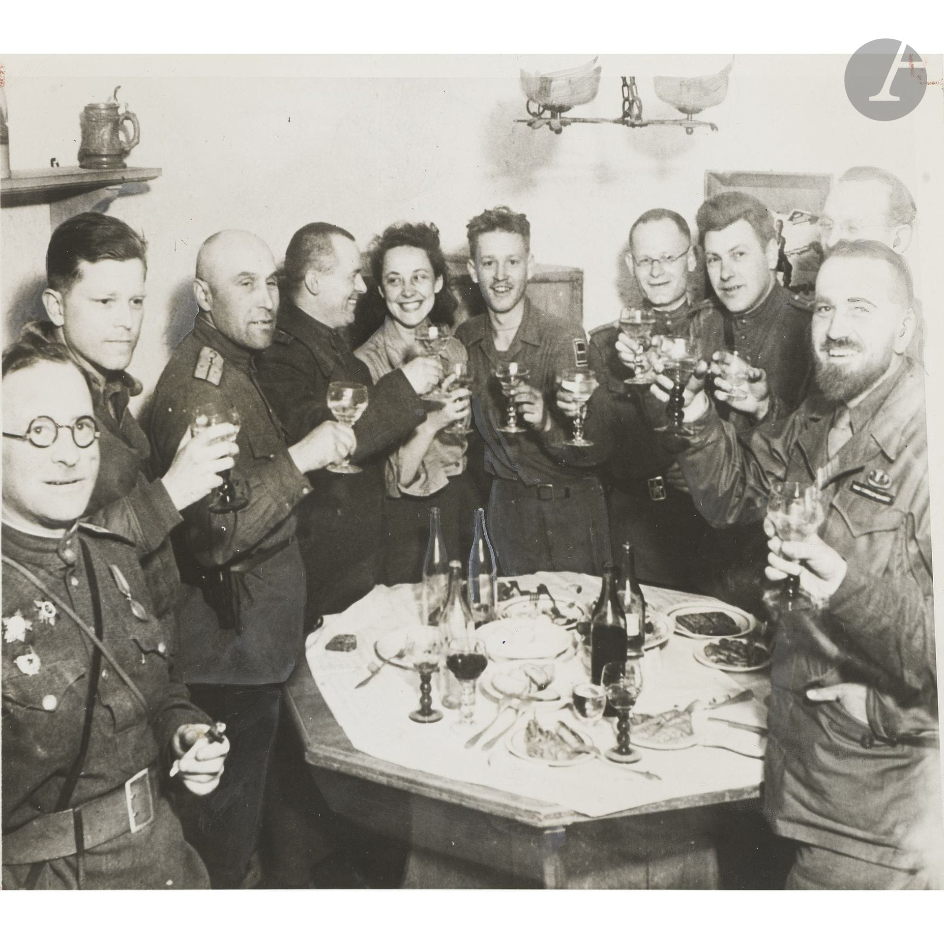 World War II, 1939–1945.
American and Russian soldiers toast to victory. Torgau, Germany, March 5, 1945.
Vintage silver print. Press stamps, annotations, and a typewritten caption on a label on the reverse.
Image: 17 x 20.5 cm - Sheet: 18 x 23 cm