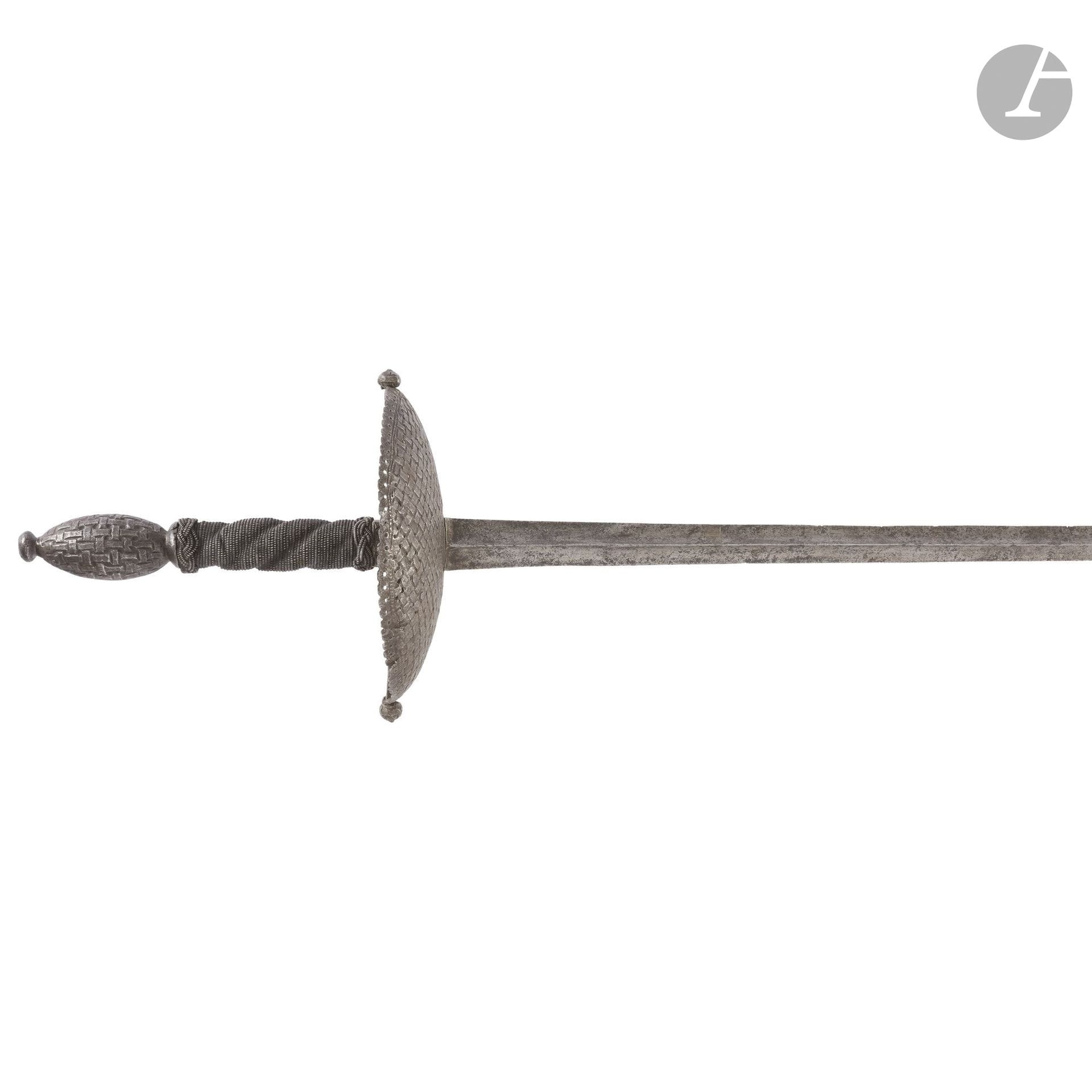 Épée de duel.
Monture en fer. Fusée en bois filigrané en torsades. Pommeau olive ciselé en vannerie. Fin quillon droit boulé et deux petits pas d’âne.
Large coquille sphérique à jour ciselé en suite. Longue et fine lame triangulaire à gouttière centrale.
Longueur : 140 cm
Troisième quart du XVIIe siècle. Ancienne restauration cassée, lame en deux parties.