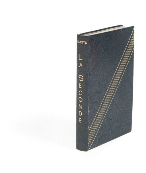 COLETTE. La Seconde. Roman. Paris : J. Ferenczi & fils, (1929). — In- 8, 270  pp. , (1 f.), couverture imprimée. Maroquin bleu nuit, série de sept filets dorés en diagonale sur les plats, dos lisse, encadrement de maroquin bleu nuit à l’intérieur, doublures de box vert amande bordé d’un triple filet doré, gardes de box vert amande, doubles gardes de japon pelure, tête dorée, non rogné, couverture et dos conservés, étui (Smet).

Édition originale.
Dans ce roman, Colette met en scène Fanny et Jane, deux femmes qui réussissent à préserver leur grande amitié malgré leur amour pour le même homme.
Un des 200 exemplaires hors commerce sur papier simili-japon de couleurs, imprimés spécialement pour l’auteur. Celui-ci est sur papier vert et comporte la signature autographe de l’auteur.
Bel exemplaire en reliure doublée de Smet. Légères craquelures aux charnières.