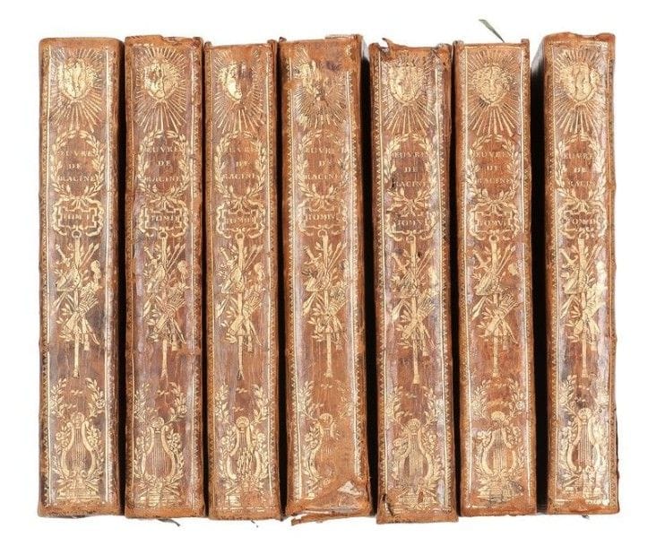 RACINE (Jean). Œuvres de Jean Racine, avec des commentaires, par M. Luneau de Boisjermain. Paris : imprimerie de Louis Cellot (chez Charles Panckoucke), 1768. — 7 volumes in- 8, (4  ff.), cxliv, 277  pp. , 1 portrait, 2 planches ; (2  ff.), 443  pp. , 3 planches ; (2  ff.), 409  pp. , 3 planches ; (2  ff.), 432  pp. , 2 planches ; (2  ff.), 440  pp. , 2 planches ; viij  pp. , (1 f.), 436  pp. , (1 f.) ; (2  ff.), 399, 17  pp.  Veau marbré, triple filet doré en encadrement sur les plats, dos lisse orné de fers spéciaux, tranches dorées (reliure de l’époque).

Cohen, 847.
Belle édition des œuvres de Jean Racine, illustrée en premier tirage d’un portrait de l’auteur gravé par Gaucher d’après Santerre et de 12 planches gravées par Noël Lemire, Jean-Jacques Flippart, Jean-François Rousseau, Louis Lempereur, Antoine Duclos, Jean-Charles Le Vasseur, Benoît Prevost, Jean-Baptiste Simonet et Denis Née d’après les compositions de Hubert GRAVELOT.
Un des exemplaires aux reliures ornées des fers spéciaux dessinés par Gravelot, qui étaient exclusivement appliqués sur les exemplaires de présents.
Manques à plusieurs coiffes et en bas du dos du 4e volume, frottements d’usage, fente à 3 charnières, quelques travaux de vers au dos du 5e volume, coins émoussés. Rousseurs éparses, tache d’encre claire page 63 du second volume, mouillures claires dans le 4e volume.