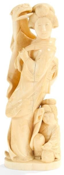 JAPON - Epoque MEIJI (1868 - 1912)
Okimono en ivoire marin, jeune femme debout portant un masque de shishimai accompagnée d?un enfant. H.: 21 cm