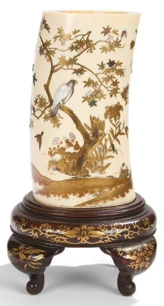JAPON - Epoque MEIJI (1868 - 1912)
Vase de forme cylindrique en ivoire décoré en laque or et incrustations «shibayama» de nacre et corail d?oiseaux et rapace posé sur des branches d?érable. H.: 19 cm Socle en bois
