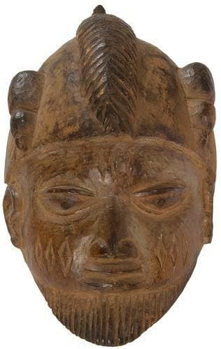 YOROUBA (Nigeria) Masque «Guélédé». Masque heaume barbu, le visage couvert de scarifications rituelles classiques de l'ethnie, patine brune, une fente ancienne stabilisée. Longueur: 31 cm Provenance: Vente Loudmer, Paris, 24 juin 1993, n°87.