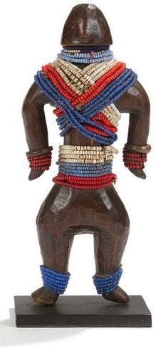 NAMJI (Cameroun) Poupée rituelle. Très belle sculpture de belle ancienneté à patine brun foncé, perlage multicolore, bracelets et grelot en bronze. Hauteur: 19,5 cm