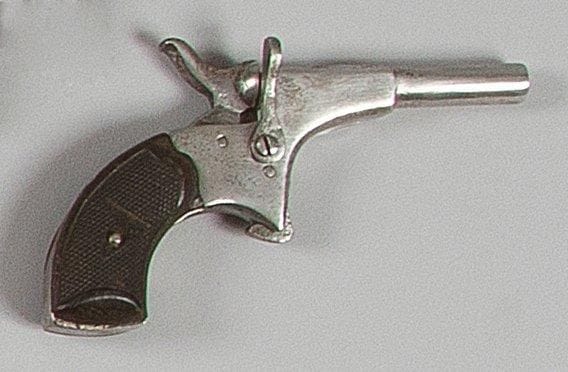 Petit pistolet dit de cycliste, un coup, calibre 5,5 mm Canon rond à pans au tonnerre, extracteur à oreille. Détente éperon. Plaquettes de crosse en bois noirci quadrillé. A.B.E. Vers 1880/1890.