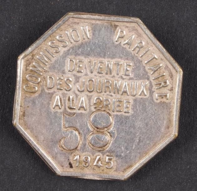 Insigne de fonction. Insigne de boutonnière de membre de la commission paritaire de vente de journaux à la criée de 1945. En métal argenté. Frappé «58» et daté. B.E.