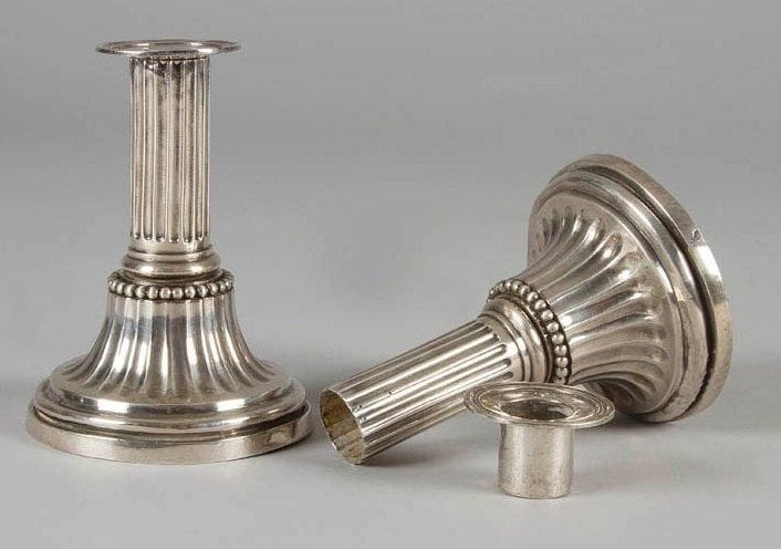 Paire de flambeaux de toilette en argent reposant sur une base ronde, l'ombilic cannelé surmonté d'une bague ciselée de perles et fût cannelé, terminé par une bobèche ronde. Gravée du chiffre: MD sous la base et sur les bobèches. Ancienne restauration sur les cannelures de l'ombilic. Montpellier 1788. Maître orfèvre: Louis II DULAURIER, reçu en 1765 Poids: 613 g - Haut.: 14,5 cm - Diam.: 10,7 cm