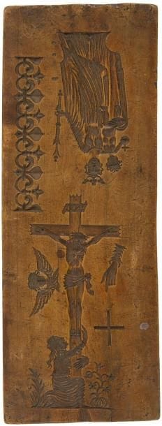 Plaque en noyer incisée en creux de motifs décoratifs tels que frise de fleurs de lys, Vierge, évêque, figure de saint, Christ en croix, cachet de signature du fondeur; probablement des moules destinés à réaliser les modèles en cire des décors appliqués sur les cloches d'église. XIXe siècle. 28,5 x 11 cm