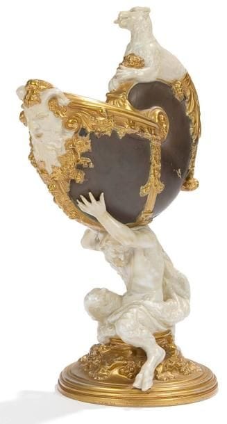 Angleterre
Nautile en porcelaine à fond brun surmonté d'un félin et supporté par une figure de satyre assis sur une base circulaire à fond or. XIXe siècle. H.: 26 cm