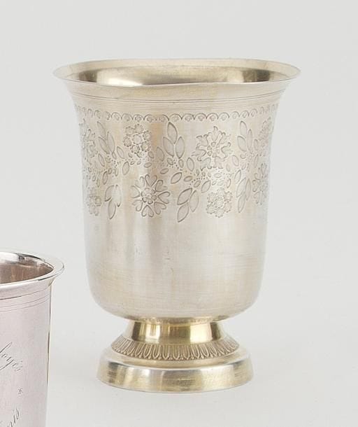 Timbale tulipe en argent anciennement vermeillée, reposant sur un piédouche à décor de feuilles de laurier, la coupe gravée dans sa partie supérieure d'un décor fleuri terminée par un double rangs de filets. Poinçon minerve. Orfèvre: HMB une botte liée (non identifié). Poids: 111 g Haut.: 12,1 cm