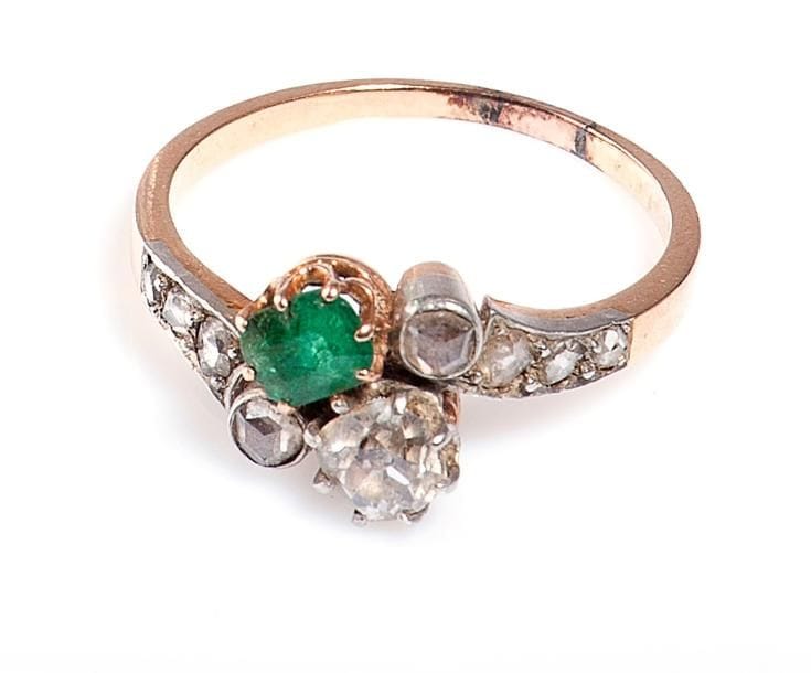 Bague en or rose, en toi et moi sertie d'une émeraude et d'un diamant, l'épaulement agrémenté de roses. Début du XXe siècle. Poids brut: 3,8 g (soudure)