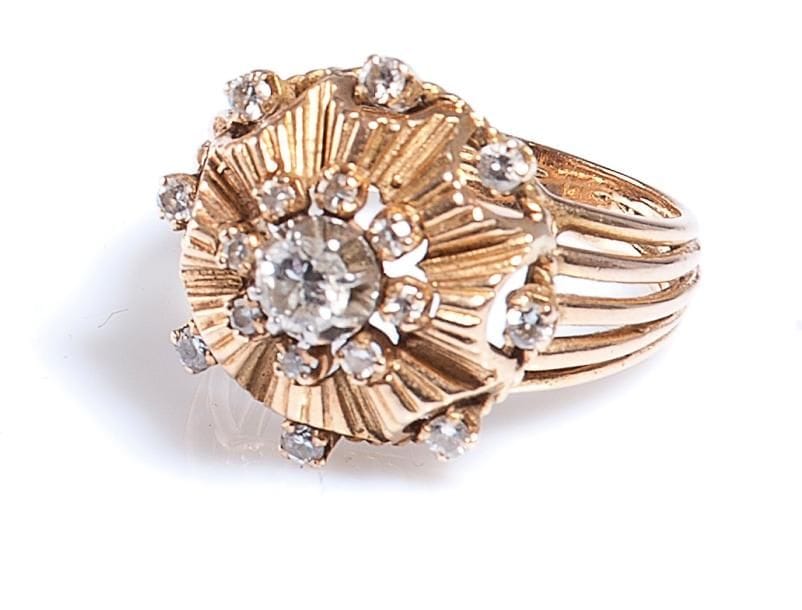 Bague en fils d'or jaune, chaton «juponné» godronné centré d'un diamant couronné de diamants plus petits. Travail français, vers 1950. Poids brut: 6,7 g