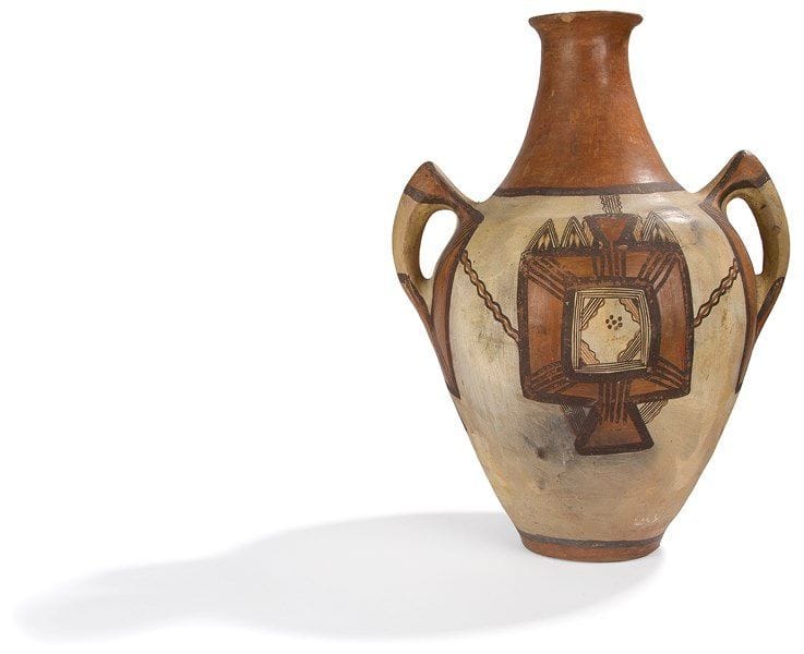 Jarre takeduht, berbère, Grande Kabylie, Arumu Tebalt, début du XXe siècle Jarre à deux anses, à panse globulaire en terre cuite peinte en ocre et noir sur fond crème orné de deux larges motifs géométriques terminés en trapèze. H.: 52 cm 


A two handled jar, takeduht, Berber, Great Kabylia, Arumu Tebalt, early 20th century