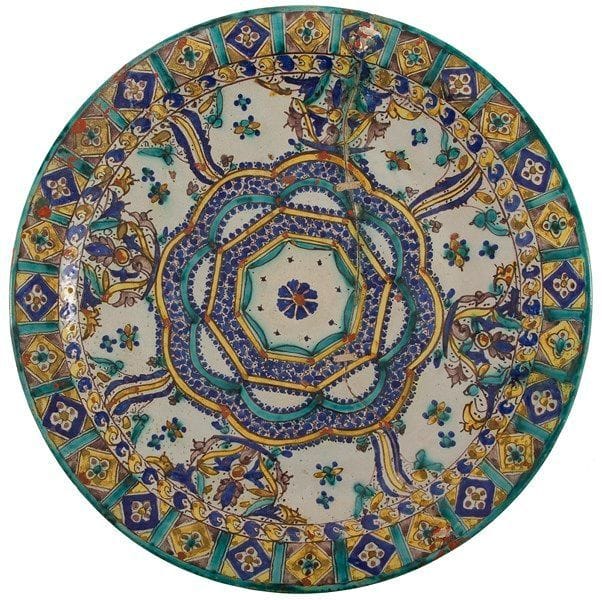 Plat, mokhfia, Maroc, Fès, signé et daté 1332H./1913 Grand plat en faïence, à décor polychrome et rehauts de minium, d?un large octogone inscrit dans un polylobe bordé de compositions florales et de motifs en esse. Frise de quadrilobes au rebord. D.: 50,5 cm État: fracture et réparations par cordage recouvertes de minium. Provenance: collection J. M. G., Paris. 


Dish, Mokhfia, Morocco, Fez, signed and dated 1332 H / 1913