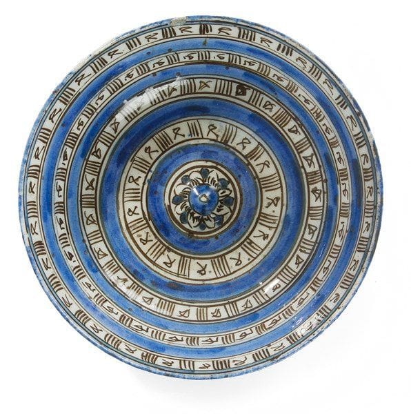 Bol à ombilic, Iran qâjâr, fin du XIXe siècle Bol en céramique siliceuse peinte, sur fond blanc, en bleu et noir sous glaçure transparente. À décor de quatre lignes concentriques ornées d?inscriptions stylisées. Au revers, deux lignes concentriques similaires. On y joint une petite lampe à huile en céramique bleu turquoise, Iran Seljoukide. Diam.: 21 cm État: une petite restauration sur le rebord. Provenance: Ancienne Collection J. Soustiel, Me F. de Ricqlès, Hôtel Drouot, vente publique du 6 déc. 1999, partie du lot 287.
 

A blue, black and white pottery bowl and a small pottery oil lamp, late 19th century