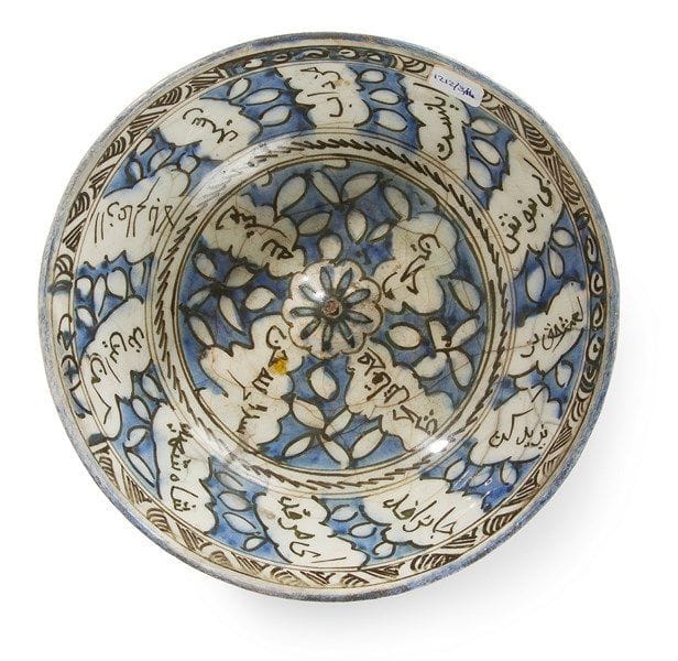 Bol à ombilic, Iran qâjâr, fin du XIXe siècle En céramique siliceuse à décor bleu et noir sous glaçure transparente sur fond blanc. Dans le rondeau central autour de l?ombilic se déploient quatre cartouches calligraphiés en persan, en réserve sur un fond végétal; il s?agit d?invocations poétiques concernant le martyr d?Hossein à Karbala. Le même décor est repris sur la paroi. Au revers, décor de mandorles, de volutes et de frises géométriques. Diam.: 22,5 cm État: restaurations sur le rebord. Provenance: Ancienne Collection J. Soustiel, Me F. de Ricqlès, Hôtel Drouot, vente publique du 6 déc.1999, partie du lot 287.
 

A pottery bowl with Persian inscription about Imam Hussain, Qajar, Iran, late 19th century