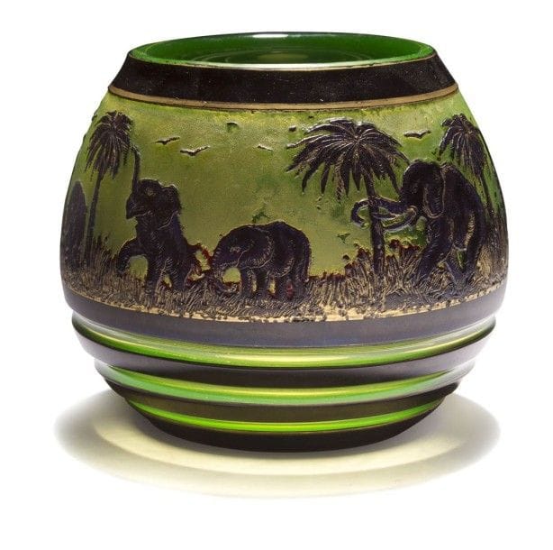 Cristallerie Ludwig MOSER & Söhne à Karlsbad

Les éléphants dans la palmeraie
Vase ovoïde à large col annulaire.
Épreuve en cristal multicouche dégagé à l’acide au décor tournant aubergine sur fond anis en partie rehaussé à l’or.
Circa 1920/30.
Signé MOSER Karlsbad, gravé en lettres cursives sous la base.
Hauteur : 13 cm