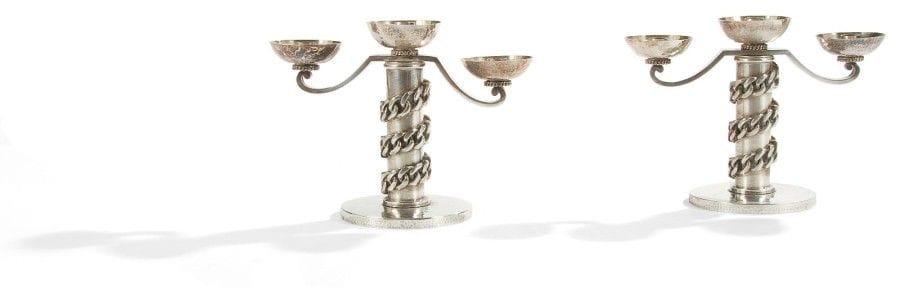Jean DESPRÉS (1889-1980)

Rare paire de candélabres à trois lumières en métal argenté à surface, en grande partie, martelée. 
Les fûts cylindriques, ornés d’une épaisse gourmette à maillons plats en application, reposent sur une base circulaire martelée.
Les bras de lumière en volutes reçoivent des bobèches semi-sphériques martelées reposant sur une discrète gourmette tournante. 
Chaque candélabre est signé J. DESPRÉS sous la base. 
22,2 x 30 x 14,7 cm
À noter :
La photographie d’époque de ces candélabres, prise dans la galerie de Jean Després à Avallon, sera remise à l’acquéreur.
Provenance :
Madame Yvonne ANDRÉ à Vézelay, Yonne. Œuvre commandée et acquise auprès de l’artiste dans sa galerie d’Avallon, Yonne. 
Par descendance, Madame L-D. D. à Châteaudun, fille de la précédente.