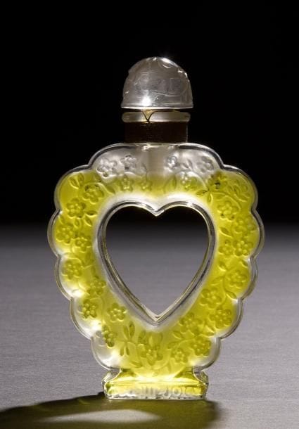 Marc LALIQUE (1900-1977)
Cœur Joie, grand modèle, pour Nina RICCI modèle créé le 19 novembre 1942
Flacon de parfum.
Corps en cristal soufflé moulé et, en partie, satiné.
Bouchon en cristal moulé pressé et, en partie, satiné.
Épreuve d’édition ancienne.
Scellé et parfum d’origine.
Signé LALIQUE France sous la base, titré et marqué Nina RICCI en creux sur chaque face du talon.
Hauteur  :  15 cm
Bibliographie  :
«R. Lalique, catalogue raisonné de   l’œuvre de verre » Félix Marcilhac, Les Éditions de l’Amateur, Paris, 2004. Modèle identique reproduit page 941 et inscrit sous la référence Nina Ricci « Cœur Joie ».